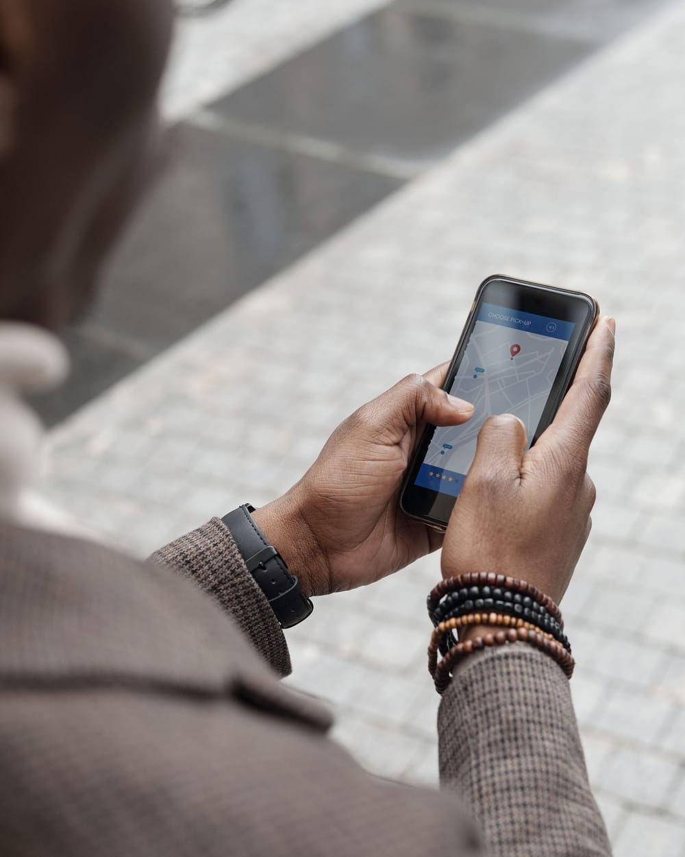 A person holding a smartphone and searching a map for a nearby location