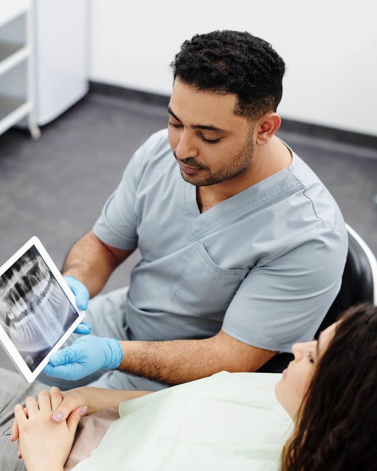 A dentist showing a dental x-ray on a tablet to a patient